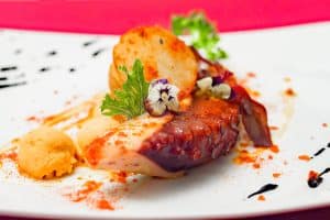 Pulpo brasa con patatas al horno y allioli de tinta de calamar con helado AOVE en Restaurante Cas Carreter